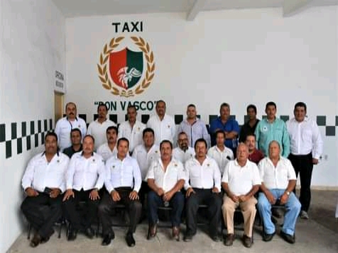 Fotografía de todo el equipo de taxis Don Vasco en grupo con camisa blanca